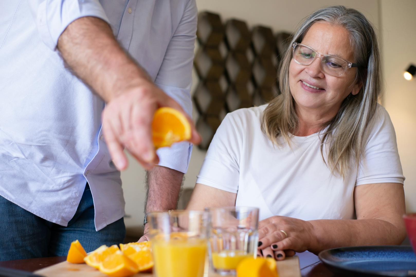 woman looks on as oranges are squeezed